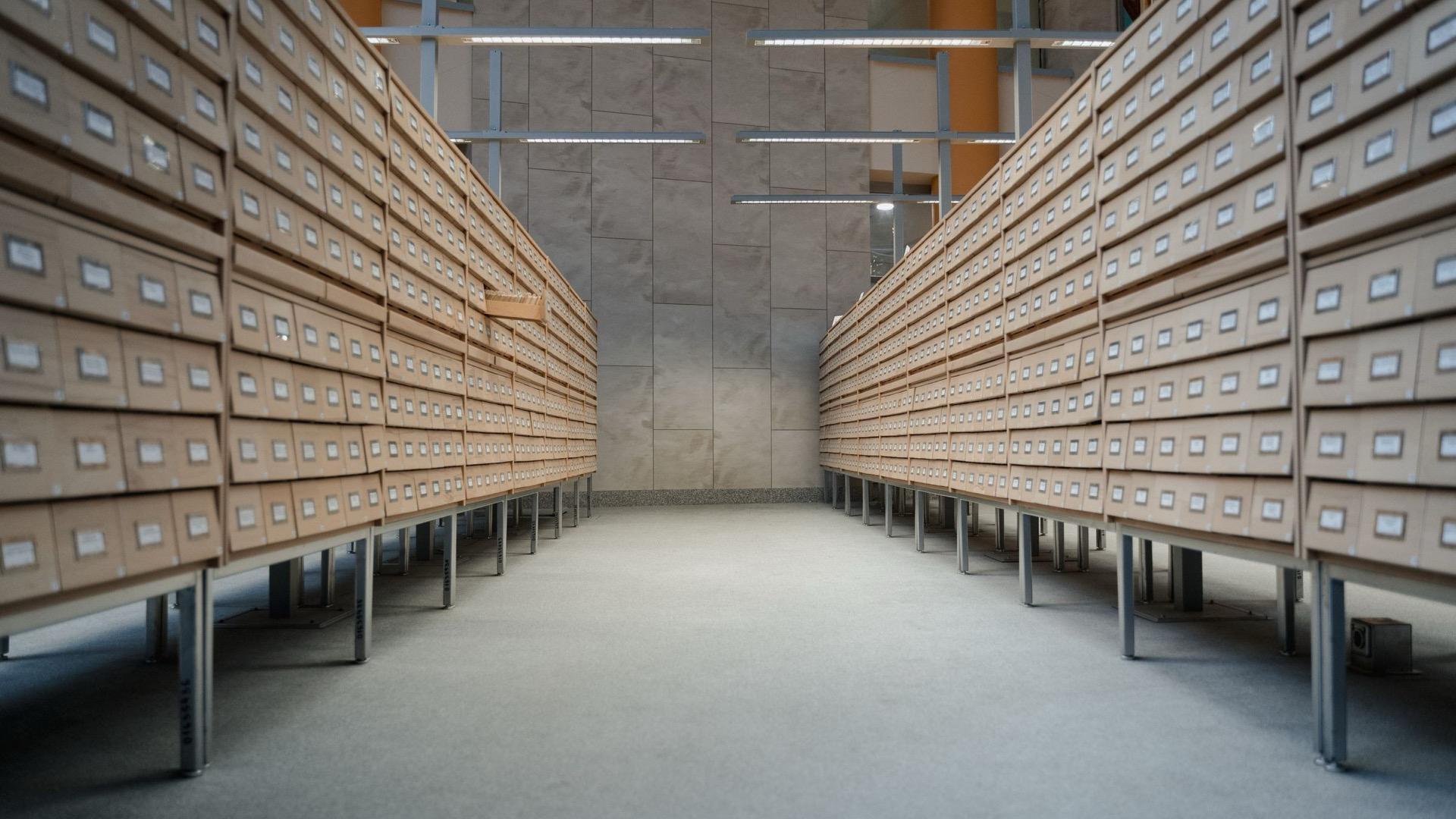 Two long banks of wooden card-index drawers in an archive hall.