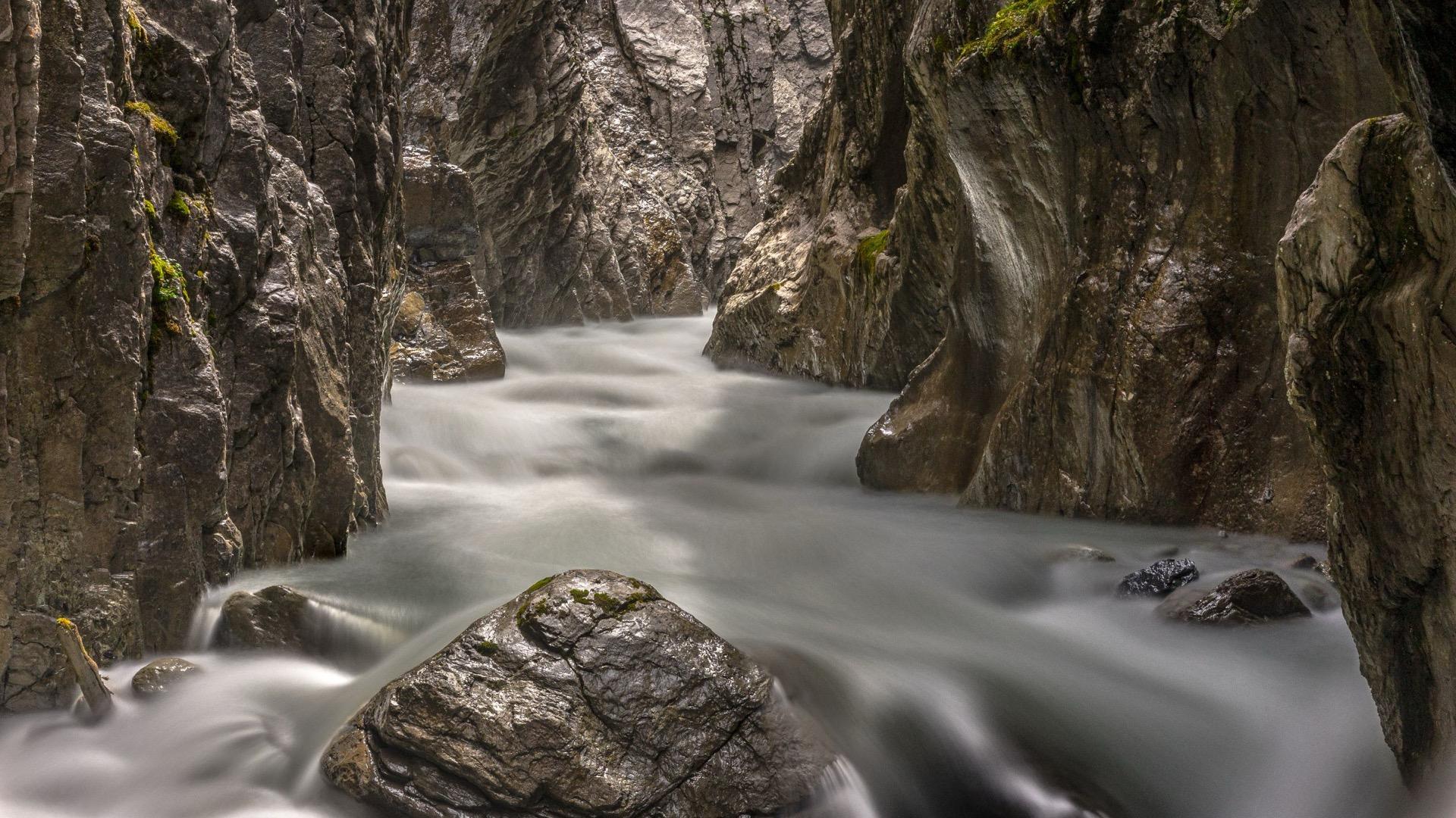 A river forced through a narrow rock gorge, the water blurred by a long exposure.